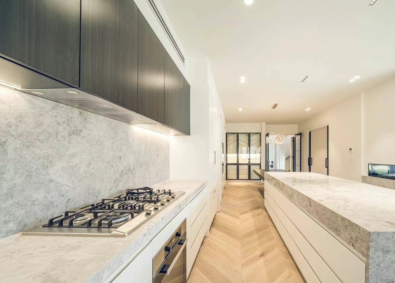Stone benchtops, integrated cabinetry and herringbone floor detail
