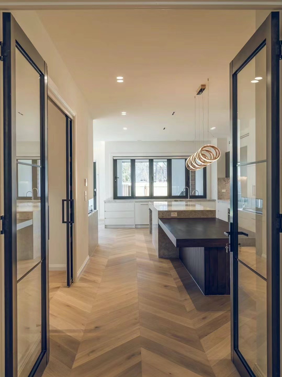 Completed Melbourne kitchen renovation viewed through black framed doors